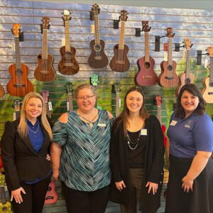 Women standing in front of guitars